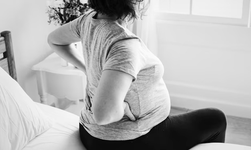 Woman-with-back-pain-sitting-on-the-bed