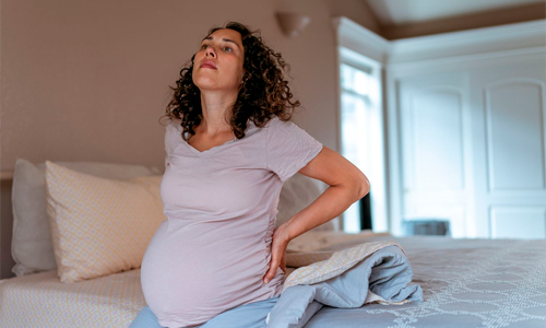 Pregnant-woman-waking-up-with-back-pain