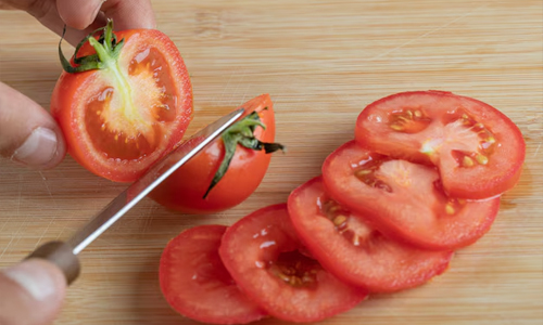 Hands-cutting-a-fresh-tomato