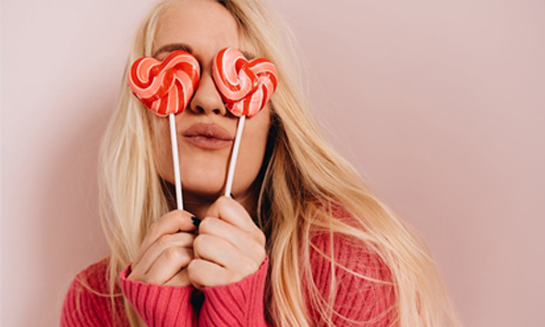 A woman with the heart-shaped lollipops in her hands